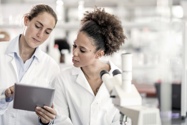 Scientists Discussing And Using Digital Tablet