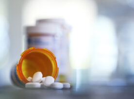 Pills Pour Out Of Prescription Medication Bottle Onto Kitchen Counter