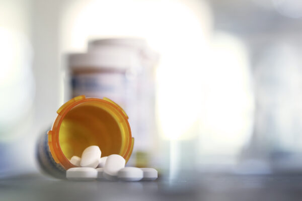 Pills Pour Out Of Prescription Medication Bottle Onto Kitchen Counter