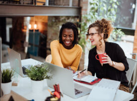 Two Businesswomen Working On Computer In Office