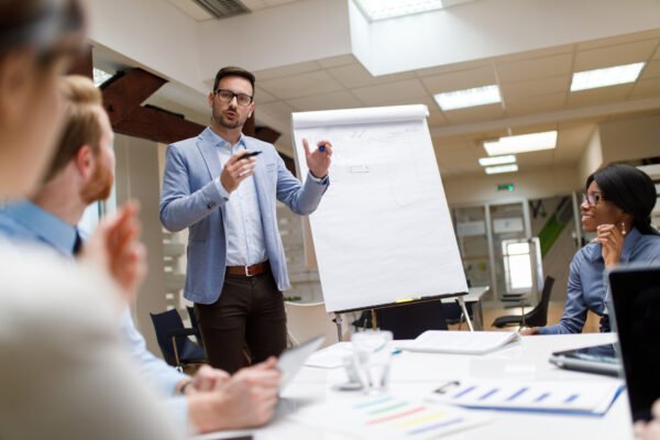 Businessman Presenting New Project To Partners In The Office