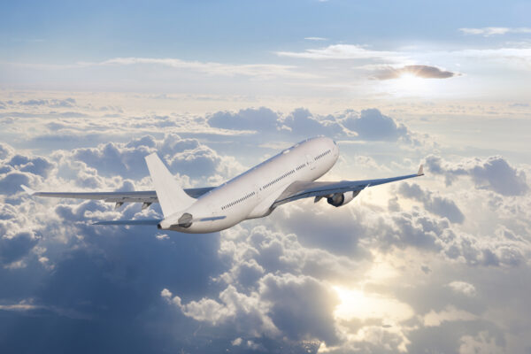 Passenger Airplane Flying Above Clouds At Sunrise