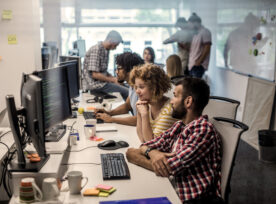 Large Group Of Computer Programmers Working In The Office.