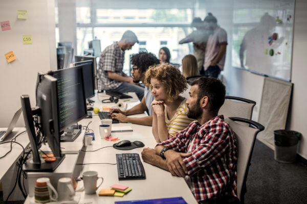 Large Group Of Computer Programmers Working In The Office.