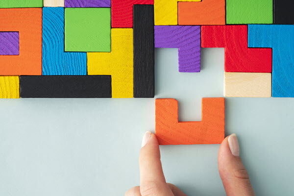 Photo of blocks being puzzle-pieced together. Using psychology to recognize idea blockers and help the pieces fit together.