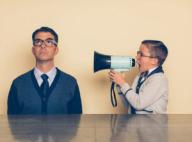 Image of a man ignoring the loud urgency of a boy screaming into a megaphone.