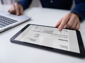 Businessman Working With Invoice On Digital Tablet