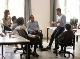 Male Team Leader Talking To Diverse Businesspeople At Office Meeting