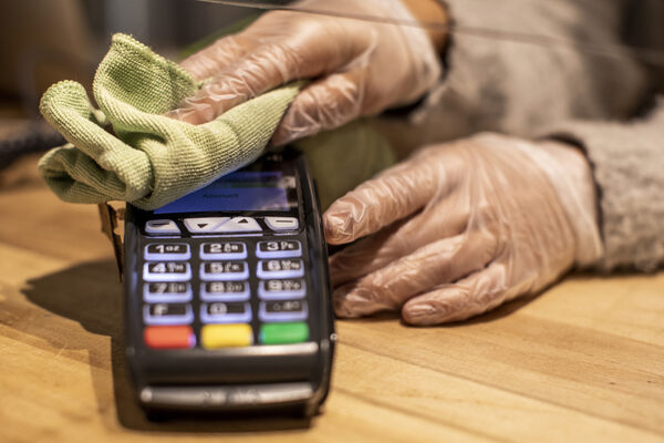 Close Up On Hands Cleaning Credit Card Reader.
