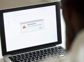 African Man Using Laptop With Application Failure Message On Screen