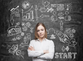 Confident woman with arms crossed in front of a blackboard showing a workflow ending in the rewards of quality innovation ideas.