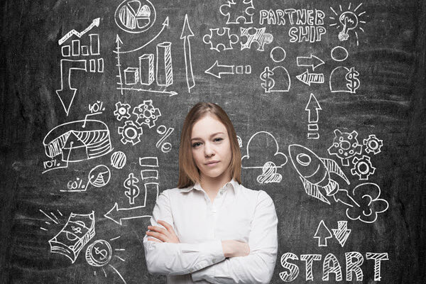 Confident woman with arms crossed in front of a blackboard showing a workflow ending in the rewards of quality innovation ideas.