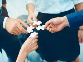 Close,up,at,a,businessman,holding,hands.,four,puzzles,come