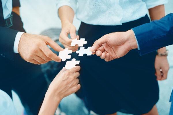 Close,up,at,a,businessman,holding,hands.,four,puzzles,come