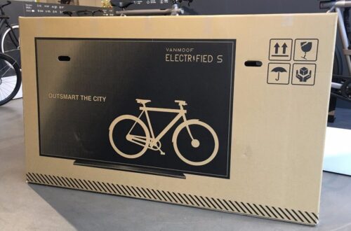 Innovative VanMoof electric bicycle packaging. Shipping box with printed HDTV displaying a bicycle illustration on the screen.