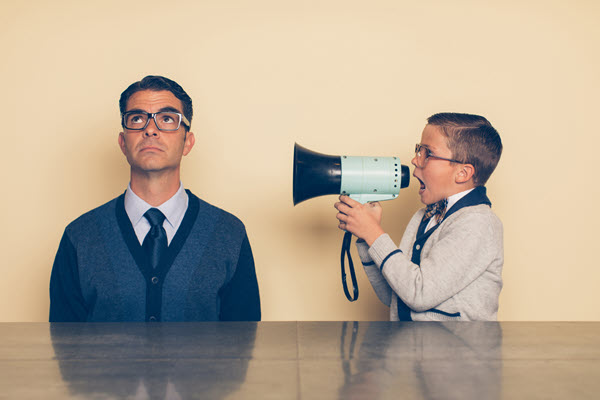 Image of a man ignoring the loud urgency of a boy screaming into a megaphone.
