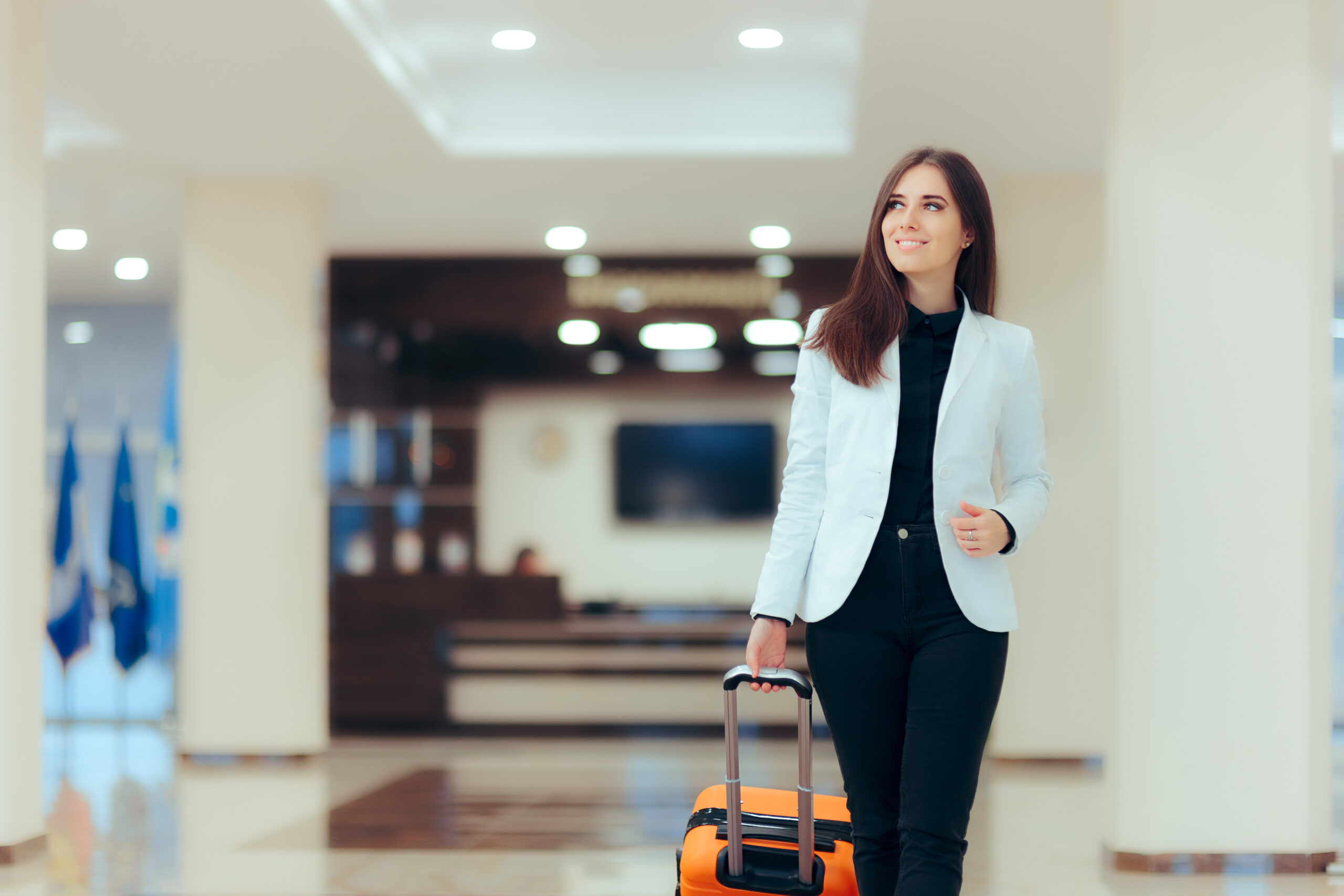 Elegant Business Woman With Travel Trolley Luggage In Hotel Lobby