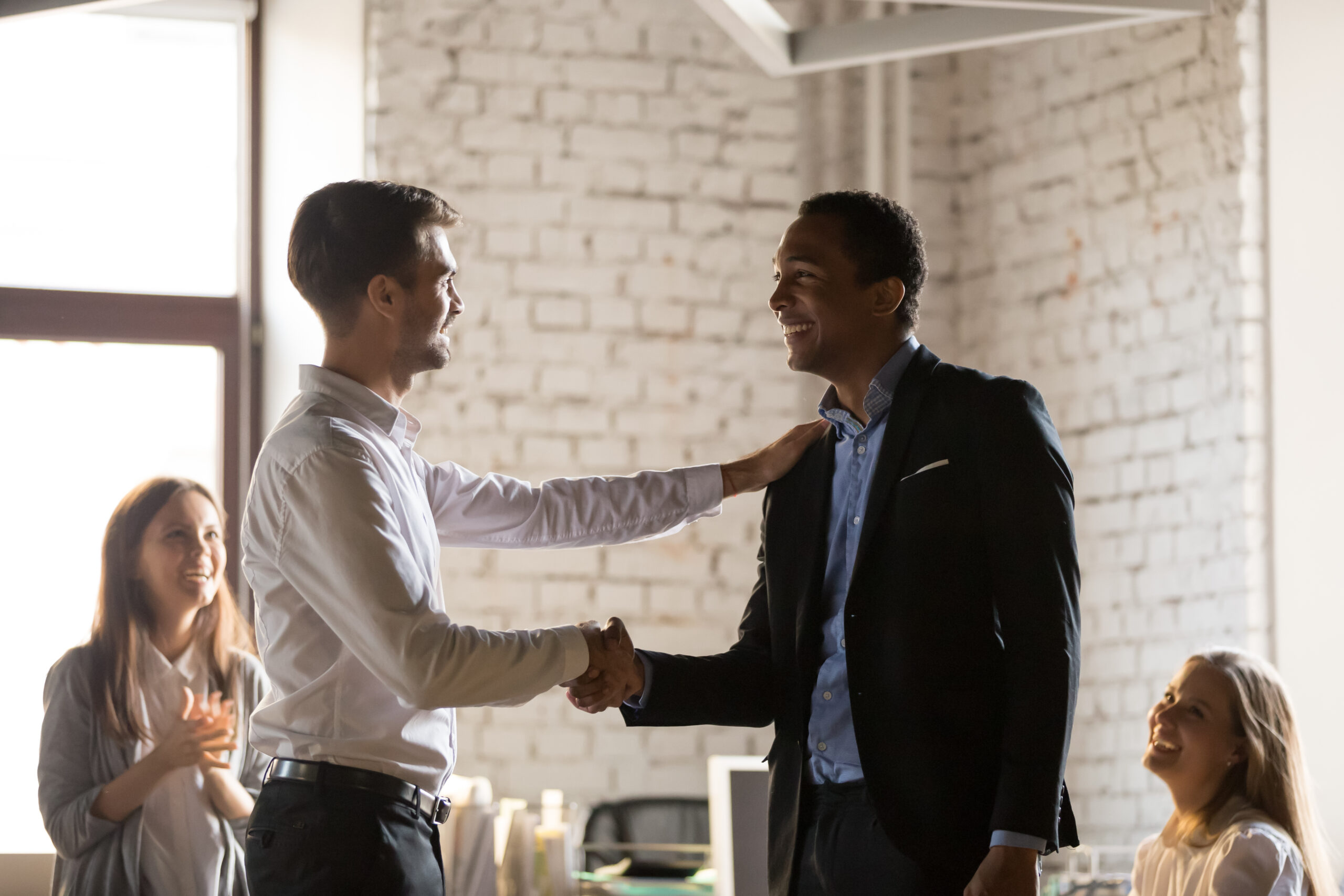 Caucasian Boss Congratulates African Employee With Promotion