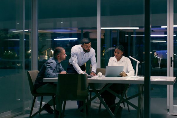 Three Colleagues Working On Laptops For Governed Ai In Banking